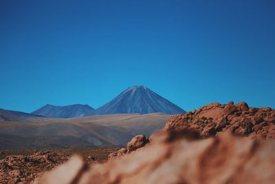 Distant view of mountain at atacama desert against clear blue sky