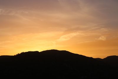 Scenic view of silhouette mountains against sky at sunset