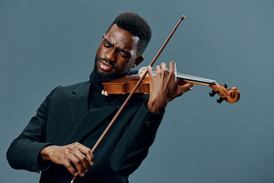 Young woman playing violin against white background