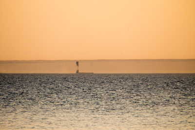 Scenic view of sea against orange sky