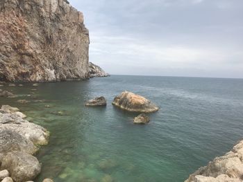 Rocks in sea against sky