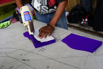 Low section of man holding paper on tiled floor
