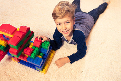 Boy playing with colorful toy blocks at home