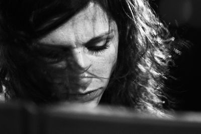 Close-up of woman with messy hair in darkroom