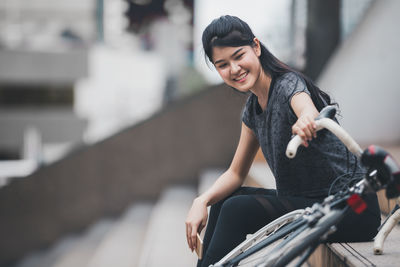 Portrait of a smiling young woman riding bicycle