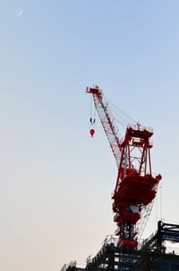 Low angle view of cranes against sky