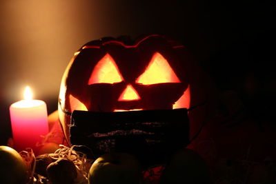 Close-up of lit candles in dark room