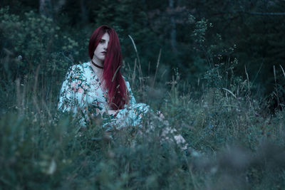 Woman standing on field in forest