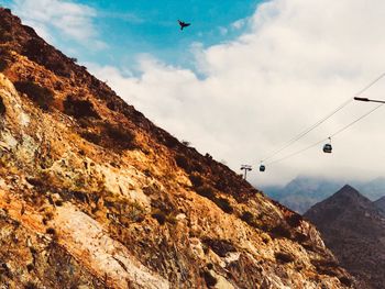 Low angle view of overhead cable car against sky