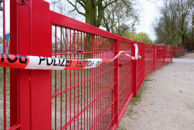 Red text on railing against trees