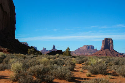 Rock formations on landscape against blue sky