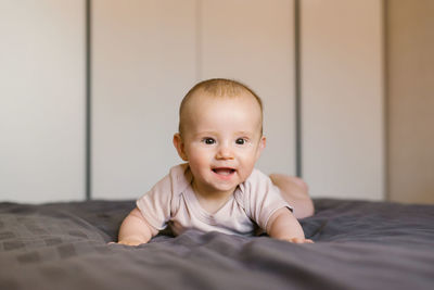 Cute baby lies on his tummy resting on his wrists.