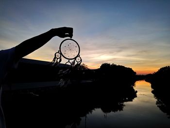 Close-up of silhouette tree against lake during sunset