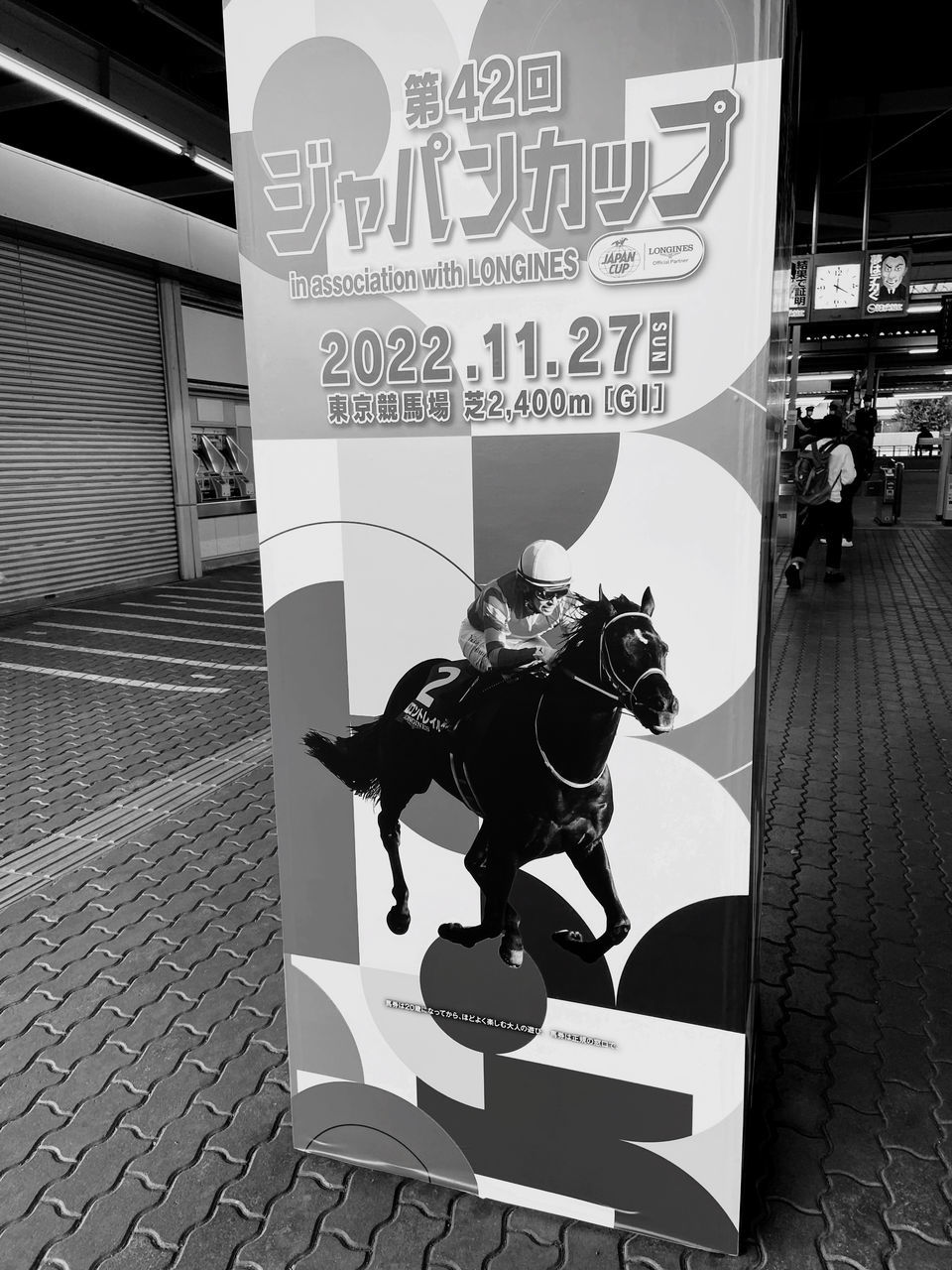 black, black and white, advertising, poster, monochrome, monochrome photography, text, communication, art, city, cartoon, footwear, architecture, footpath, western script, one person, sign, person