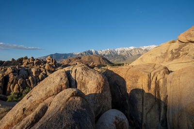 Rock formations on landscape against blue sky