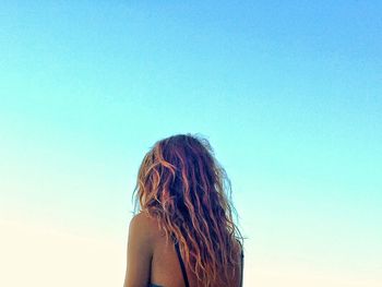 Young woman against blue sky