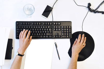 Cropped image of person using computer at office