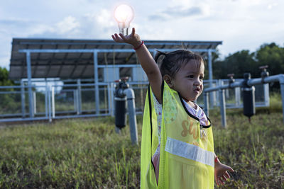 Young women and the future of renewable energy sustainable energy hold the bulb to the solar panel.