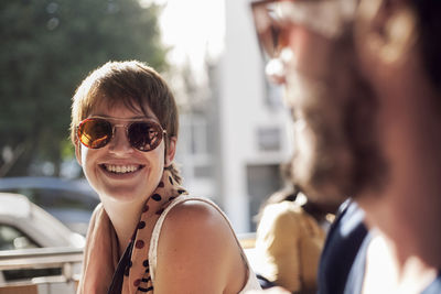 Young woman and mid adult man talking in cafe on sunny day