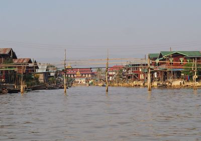 Houses by sea against clear sky