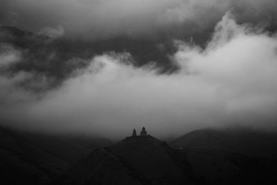 People standing on mountain against sky