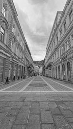 Street amidst buildings in town against sky