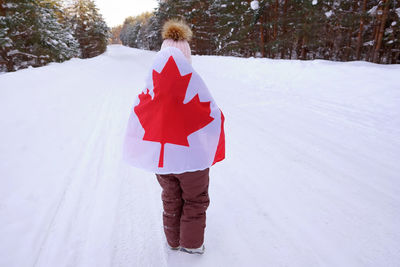 The girl is wrapped in the flag of canada