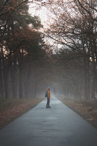 Rear view of man walking on road