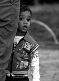 Toddler standing by man at park