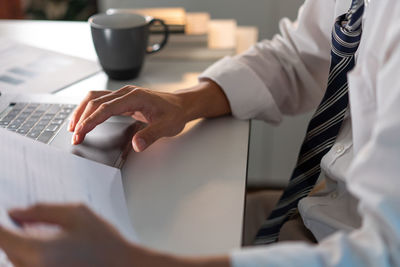 Midsection of business people working on table