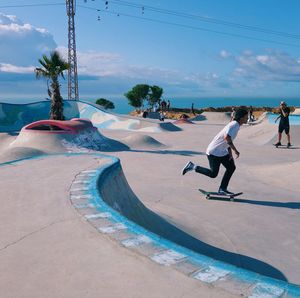 People on skateboard park against sky