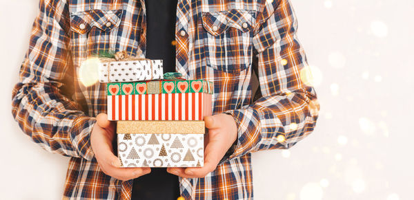 A man in a shirt holds various gift boxes. christmas and holiday concept. copy space