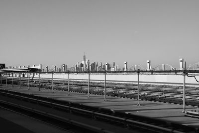 Bridge over river in city against clear sky