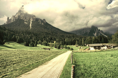 Scenic view of field and houses against sky