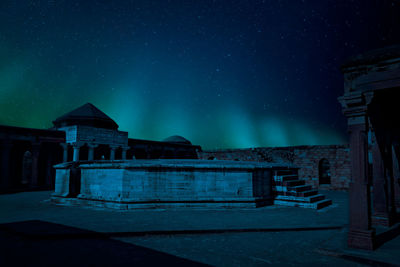 Old building against blue sky at night