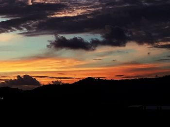 Scenic view of dramatic sky over silhouette landscape