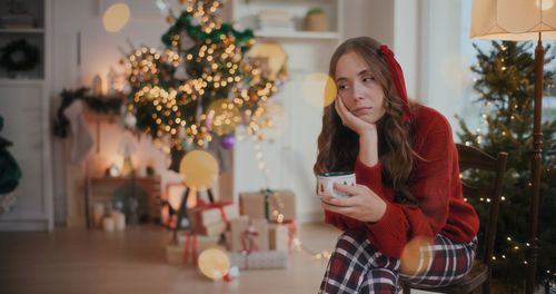 Portrait of young woman holding christmas tree