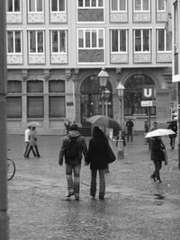 People walking on city street during rainy season