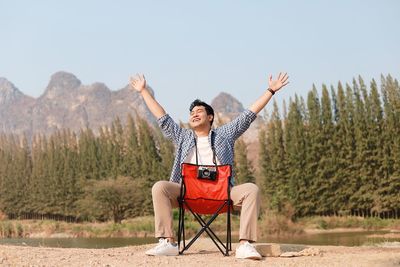 Man sitting in traditional clothing against clear sky