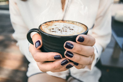 Close-up of hand holding coffee cup