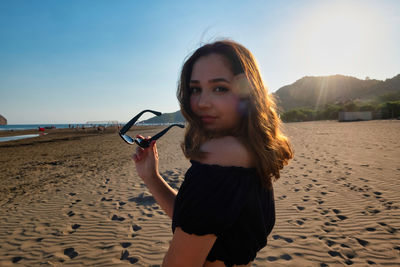 Portrait of young woman standing on beach