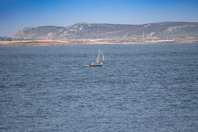 Sailboat sailing on sea against sky