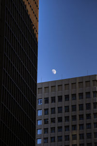 Low angle view of modern buildings against clear blue sky