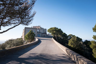 Road by building against clear sky