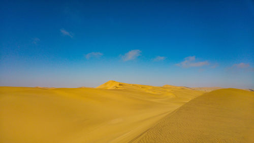 Scenic view of desert against blue sky