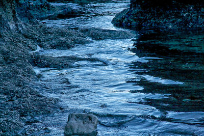 Close-up of water flowing through rocks in river