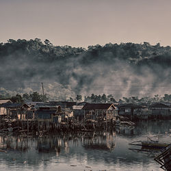 Scenic view of lake and buildings against sky