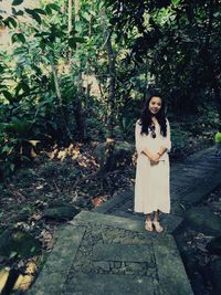 Portrait of woman standing against plants