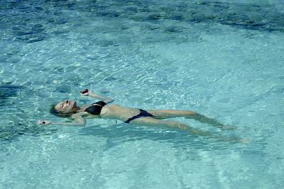 Low section of man swimming in sea