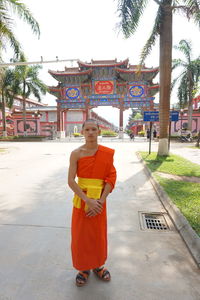 Full length portrait of young man standing against building